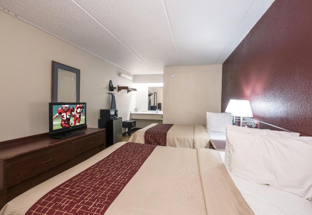 Comfortable guest room at Red Roof Inn Atlanta - Norcross featuring two beds and modern essentials for travelers seeking Norcross GA Hotel Deals